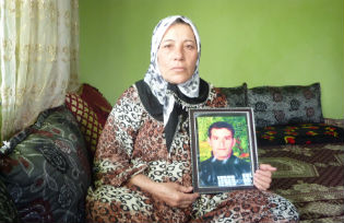 Photo of Zilfo Alma holding a portrait of her son Nadir Alma 25 one of the victims of the bombing