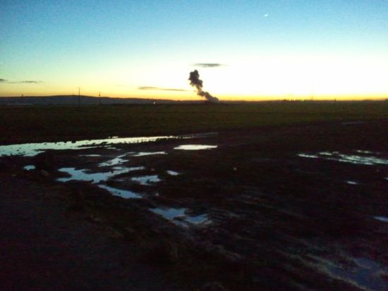 Kobanê in the dusk, from about a kilometer to the border. The tower of smoke is from an airstrike