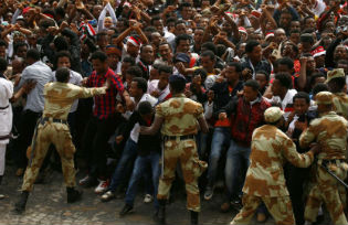 Demonstrators chant slogans and flash the Oromo protest gesture during Irreecha, the thanksgiving festival of the Oromo people, in Bishoftu town, Oromia region, Ethiopia. 